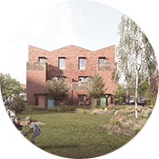 A head-on view of the new type of housing. A red brick building stands behind a green space where families are playing with their children.