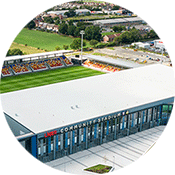 An aerial view of the York Community Stadium shows the pitch and the stands.